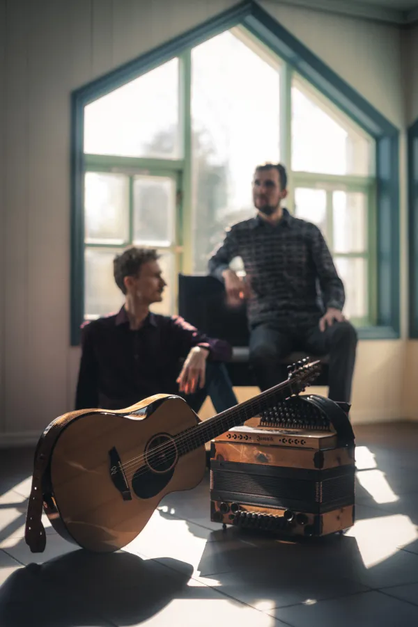 Tim & Jonnic mit Gitarre und Steirischer Harmonika am Fenster