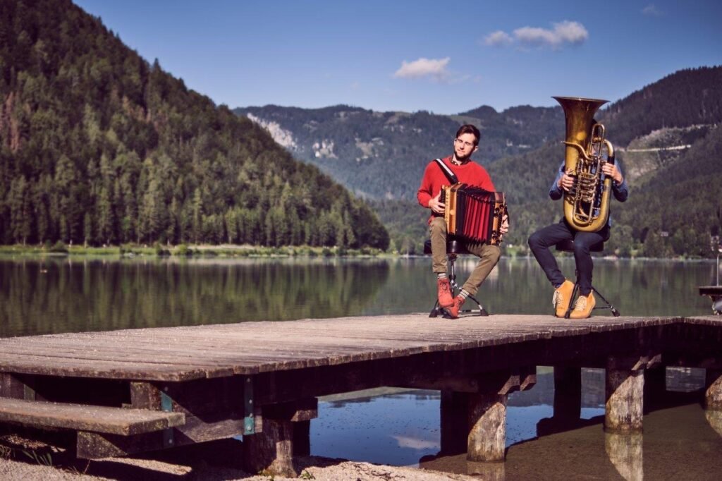 Tubonika mit Harmonika und Tuba auf einem Steg am See