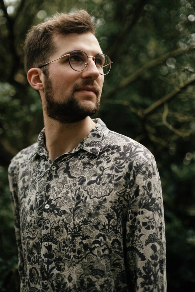 Porträt von Jonny Kölbl mit Brille und gemustertem Hemd