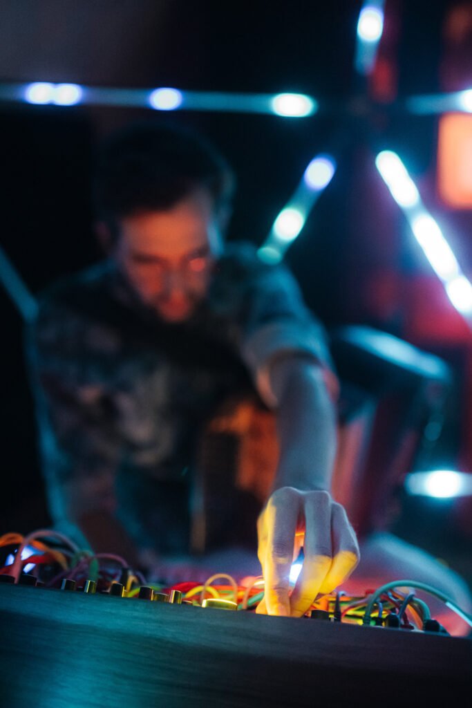Jonny Kölbl patcht den Modularsynthesizer im blauen Licht, Microcosm