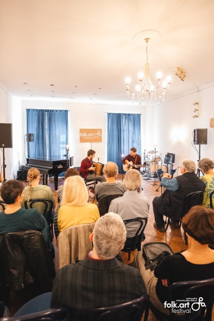Publikum bei einer Matinee von Tim & Jonnic beim folk.art Festival in einem hellen Saal